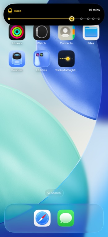 iPhone Home Screen with the Dynamic Island expanded, showing the journey strip and 16 minutes to the next stop.